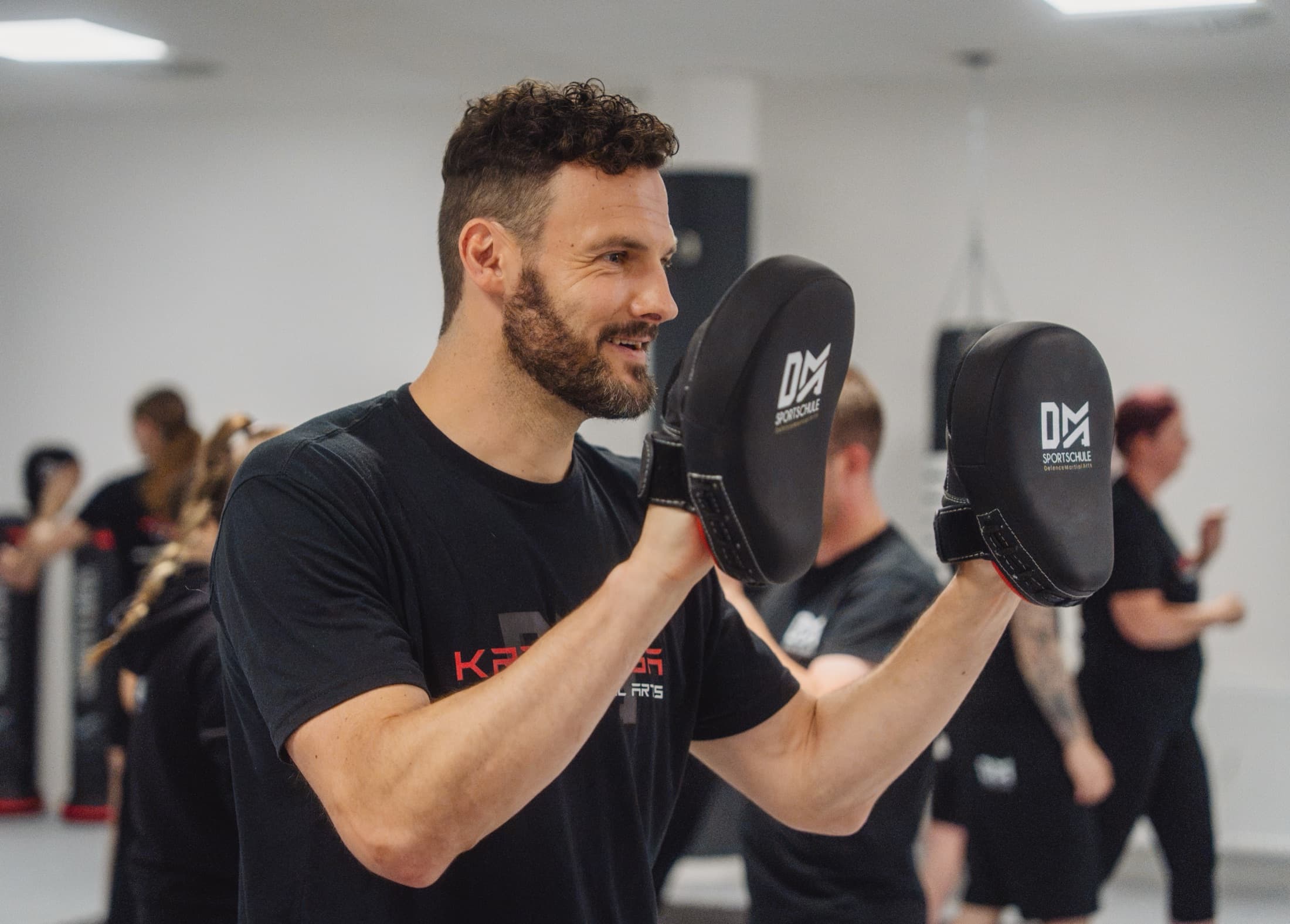 Trainer mit Pratzen im Erwachsenentraining