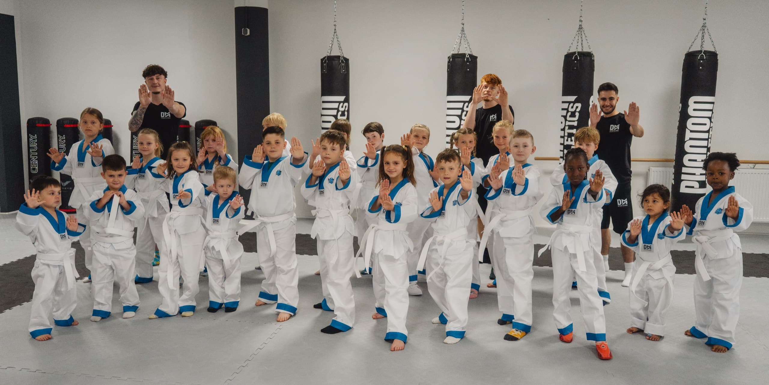 Power-Kids-Gruppe zeigt mit den Trainern die Stopp-Hand