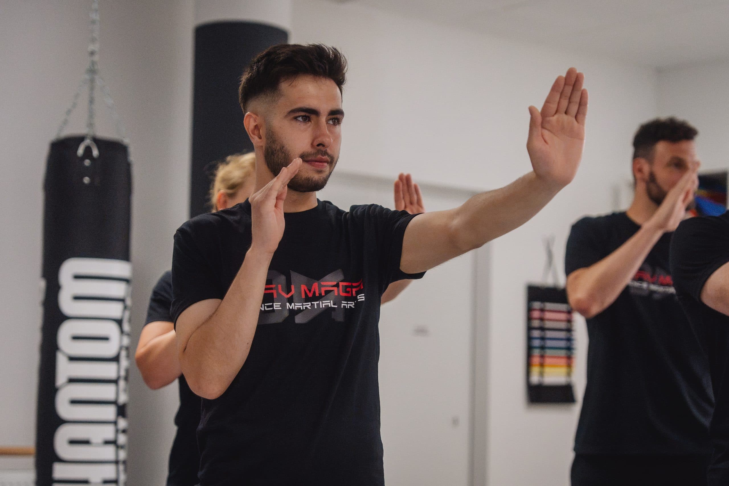 Trainierender in der Krav-Maga-Grundstellung, im Hintergrund die Gruppe