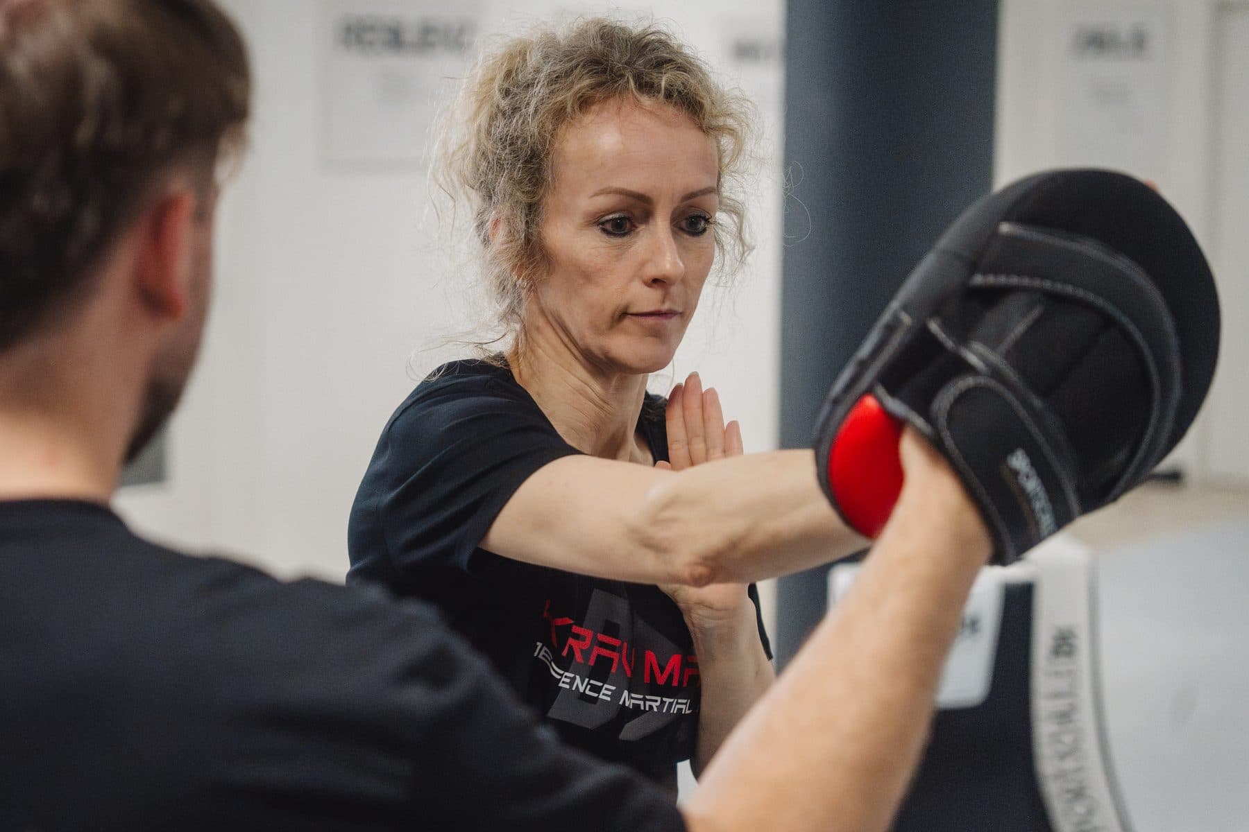 Trainierende schlägt konzentriert auf die Pratze des Trainers