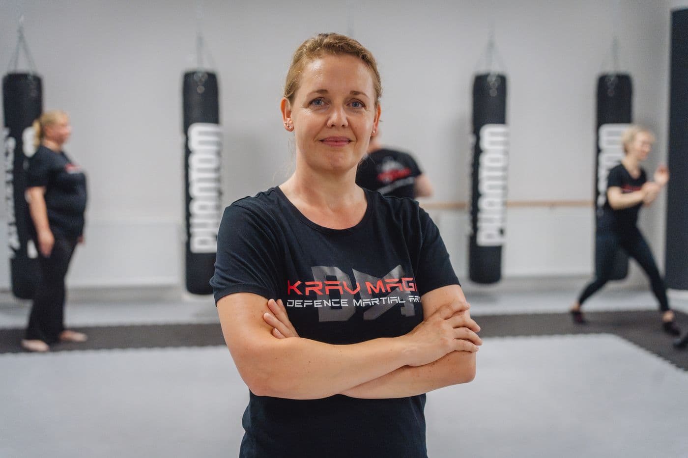 Teilnehmerin steht selbstbewusst im Trainingsraum