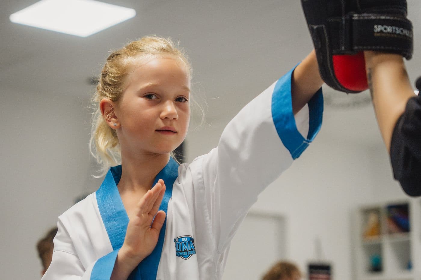 Mädchen trainiert konzentriert an der Pratze des Trainers