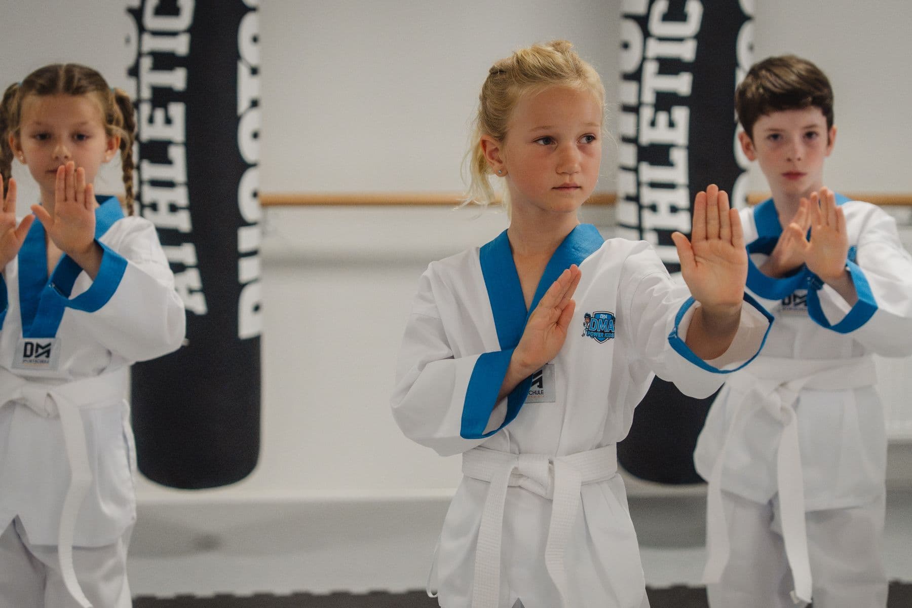 Drei Kinder zeigen konzentriert die Abwehrhaltung
