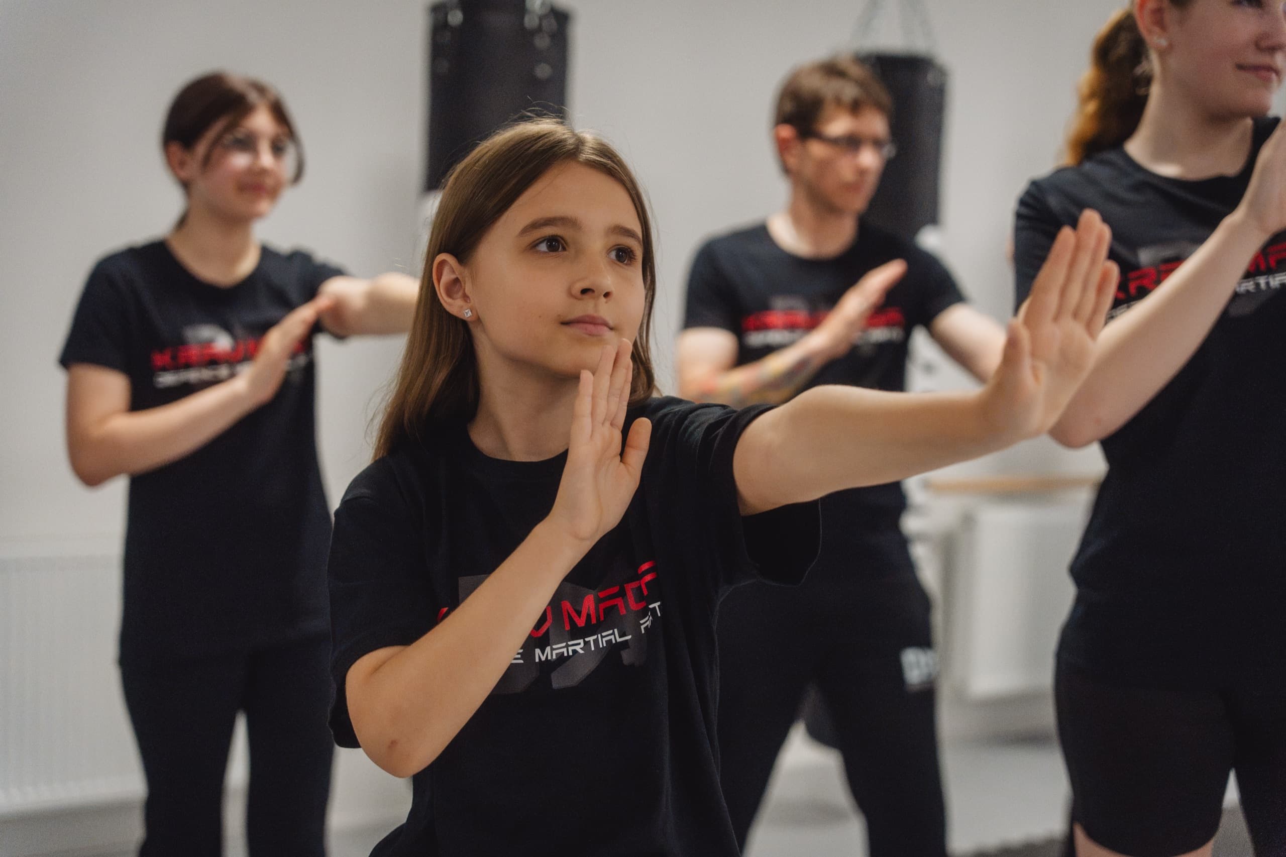 Mädchen übt konzentriert die Abwehrbewegung in der Gruppe